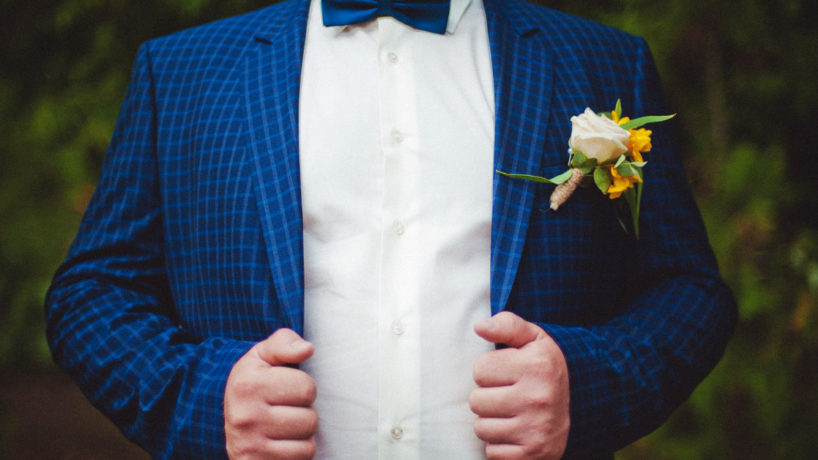 Groom holding his blue jacket