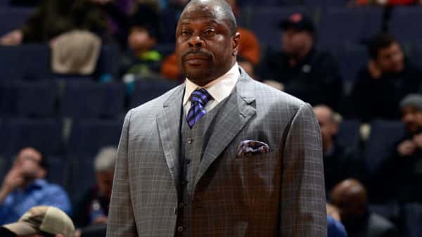 Patrick Ewing standing up wearing a suit