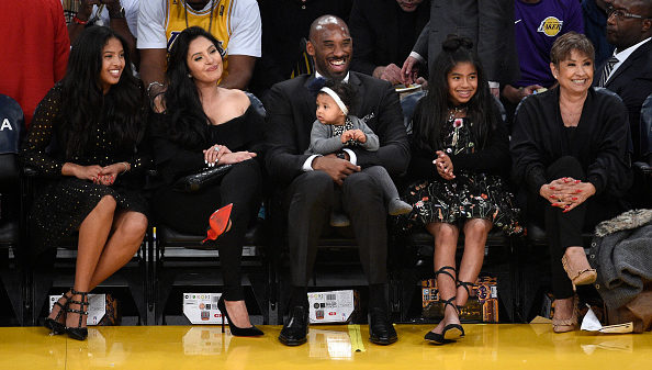 Los Angeles Lakers legend Kobe Bryant seated courtside with his family looks on during a basketball game between the Golden State Warriors and Los Angeles Lakers at Staples Center on December 18, 2017 in Los Angeles, California. The Lakers retired Bryant's #8 and #24 jersey during halftime ceremony. NOTE TO USER: User expressly acknowledges and agrees that, by downloading and or using this photograph, User is consenting to the terms and conditions of the Getty Images License Agreement.