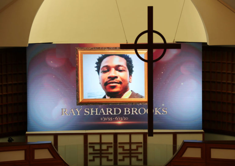 ATLANTA, GEORGIA - JUNE 22: A cross hangs from the cathedral ceiling while Rayshard Brooks is memorialized on a screen during his public viewing at Ebenezer Baptist Church June 22, 2020 in Atlanta, Georgia. Brooks, 27, died June 12 after being shot by an officer in a Wendyâs parking lot. Brooksâ death sparked protests in Atlanta and around the country. âEbenezer is a parish for all people, a sanctuary for those who suffer,â Rev. Raphael G. Warnock, senior pastor of Ebenezer, said in an emailed statement. âRayshard was not a member of our church but he, and his loved ones, are a part of our family. We seek to embrace them, comfort them and walk beside them in the days ahead.â A private funeral for Brooks will be held Tuesday at the church.