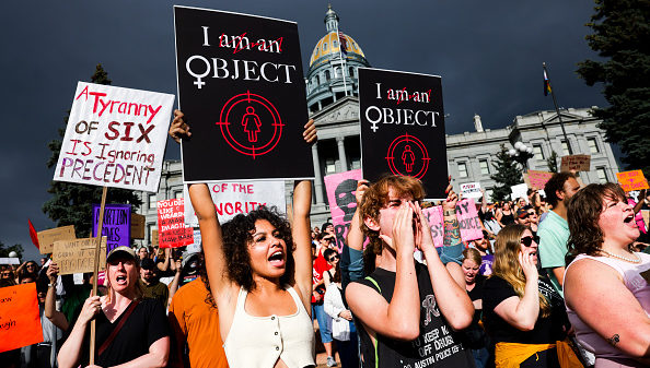 DENVER, CO - JUNE 24: Mikah Wold (L) and Paul Gollis (R) participate in a protest against the Supreme Court's decision to overturn Roe v. Wade on June 24, 2022 in Denver, Colorado. The Court's decision in the Dobbs v Jackson Women's Health overturns the landmark 50-year-old Roe v Wade case and erases a federal right to an abortion.