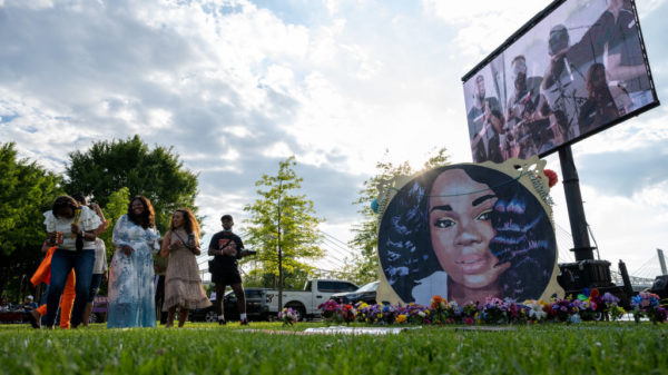 LOUISVILLE, KY - JUNE 05: People stand and laugh near an art installation depicting Breonna Taylor during the "Praise in the Park" event at the Big Four Lawn on June 5, 2021 in Louisville, Kentucky. The event commemorated what would have been Breonna Taylor’s 28th birthday. Taylor was a Black woman killed by police during a botched drug raid on her apartment on March 13, 2020, which sparked nationwide protests.