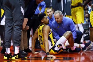 Pacers guard Jeremy Lamb sits on the ground after injuring his left knee during the 2019-20 season.