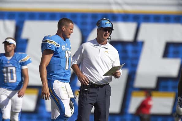 Frank Reich and Philip Rivers talks during a game.