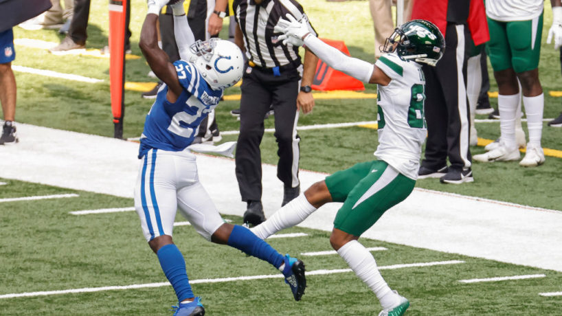 Xavier Rhodes reaches high in the air to intercept a pass off of Jets quarterback Sam Darnold with wide receiver Lawrence Cager lunging behind him