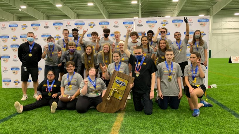 The McCutcheon Unified Flag Football Team poses for a photo on the field with their trophy