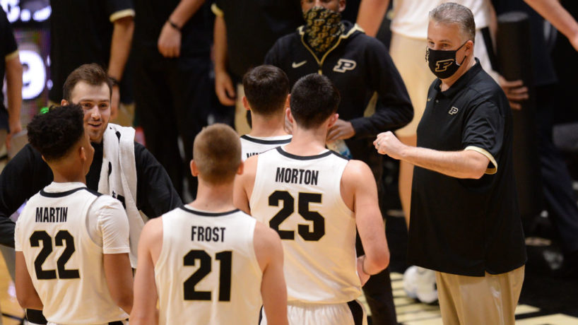 Purdue coach Matt Painter huddles around a group of players in a timeout at Mackey Arena