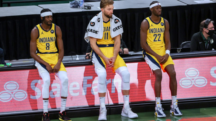 Pacers players sit on the scorer's table during a game.