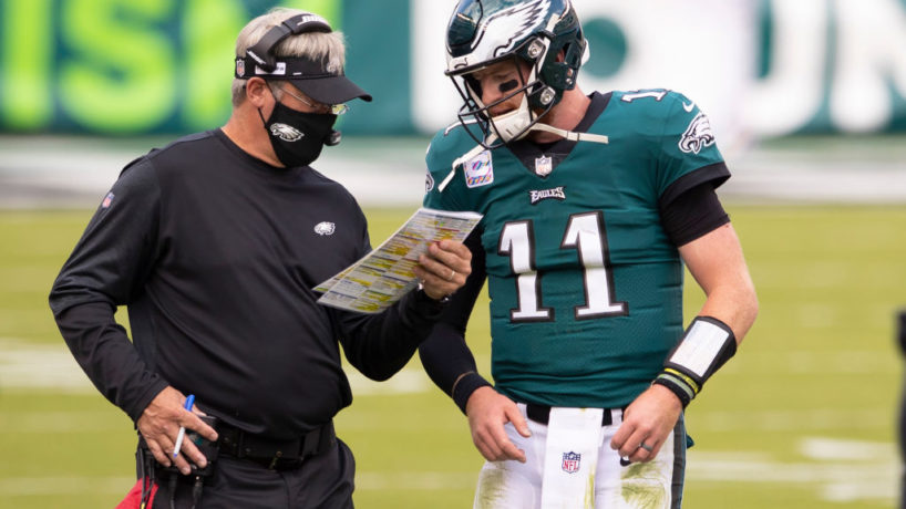 Carson Wentz and Doug Pederson talk during a game.
