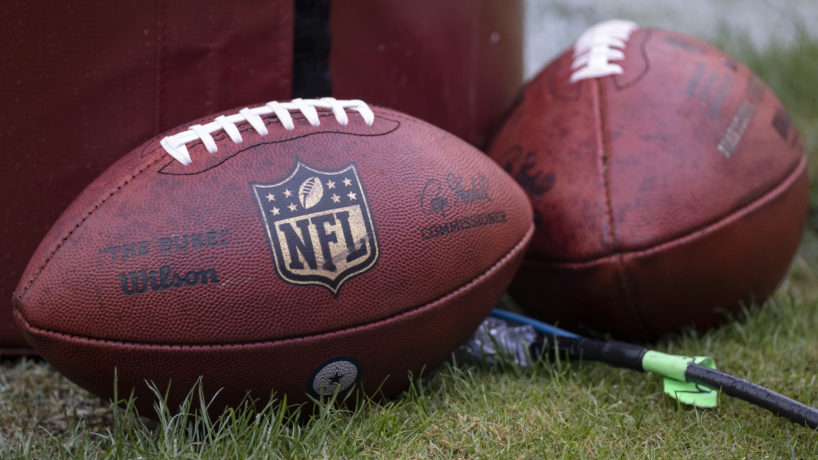 NFL Footballs leaning up against the field goal post