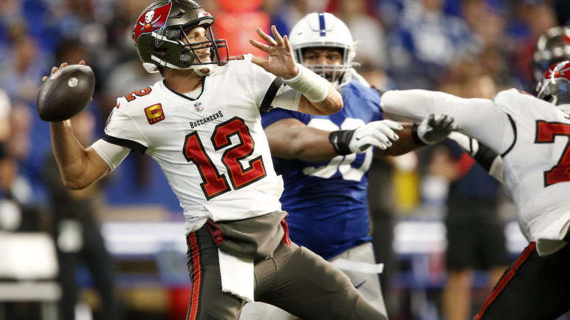 Tom Brady rears back to throw against the Indianapolis Colts as defensive lineman Grover Stewart chases