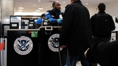 A Transportation Security Administration worker screens passengers at an airport