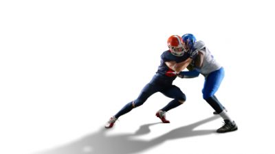 Two football players tackling each other