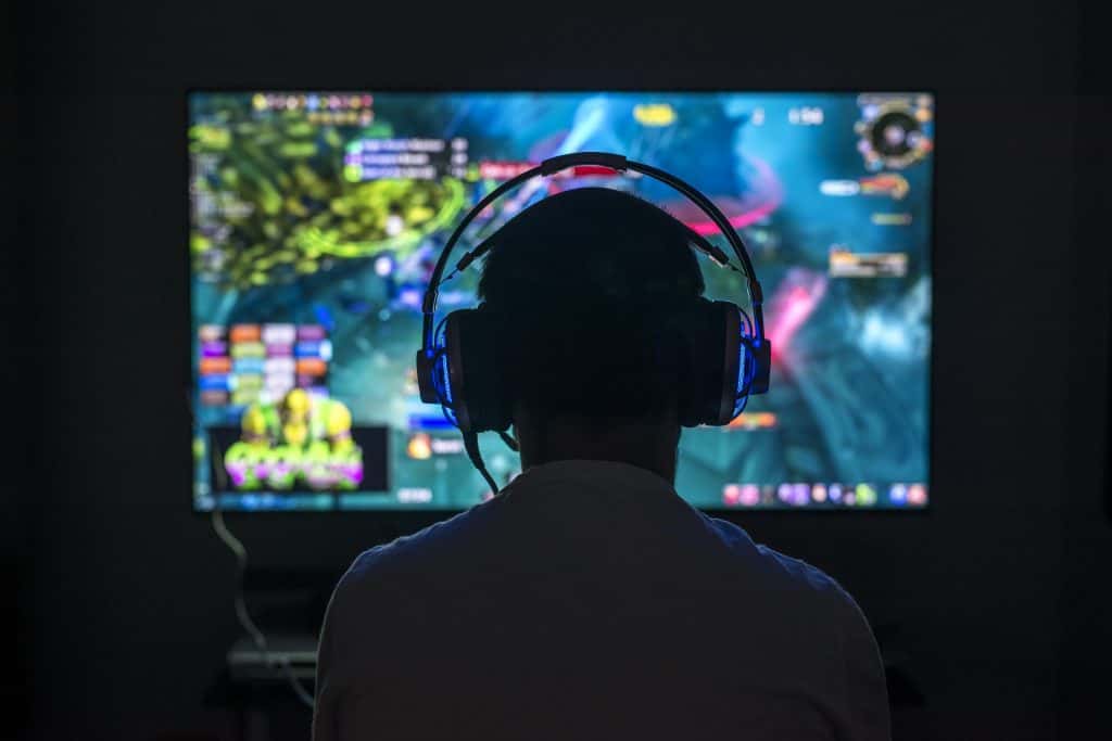 Teen playing video game wearing headphones