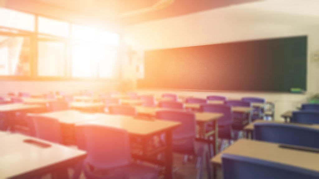 Classroom with blurry background of desks and chalkboard