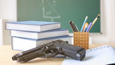 gun on desk with books