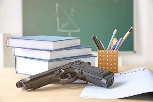 gun on desk with books