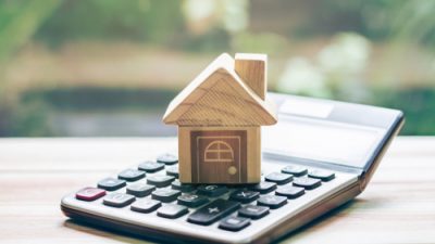 wooden house on top of a calculator