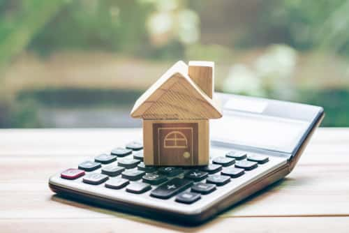 wooden house on top of a calculator