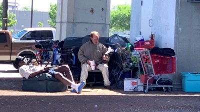 Two people relax at a homeless camp in Austin
