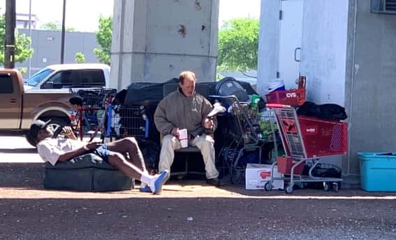 Two people relax at a homeless camp in Austin