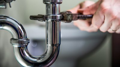 Plumber works on a pipe