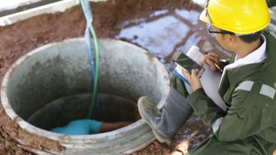 Plumbers working in open well
