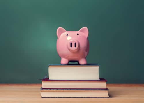 piggy bank on top of a stack of books