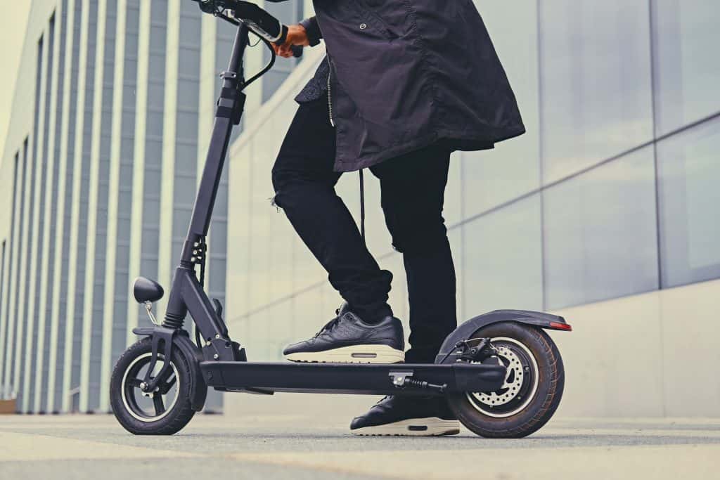 Man riding a dockless power scooter