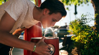 Man drinking out of water fountain
