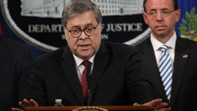 Attorney General William Barr at a news conference behind a podium