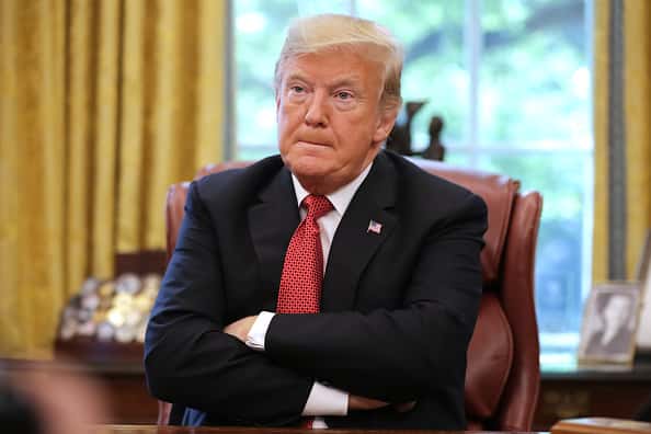 President Trump sitting in the Oval Office with arms crossed