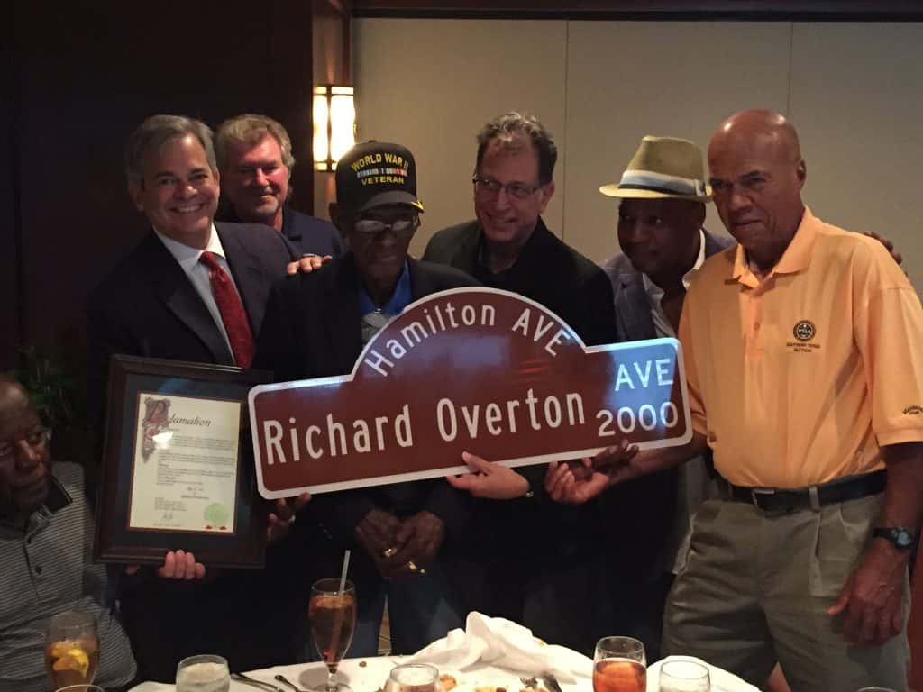 Richard Overton holding street sign with his name