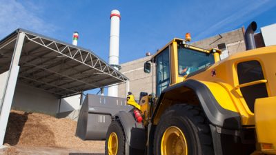 Yellow dump truck at a wood chip plant