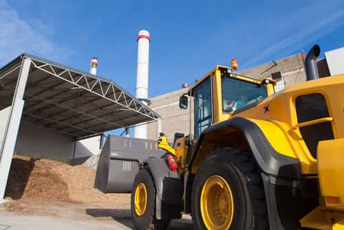 Yellow dump truck at a wood chip plant