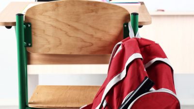 bookbag with gun hanging off of school desk