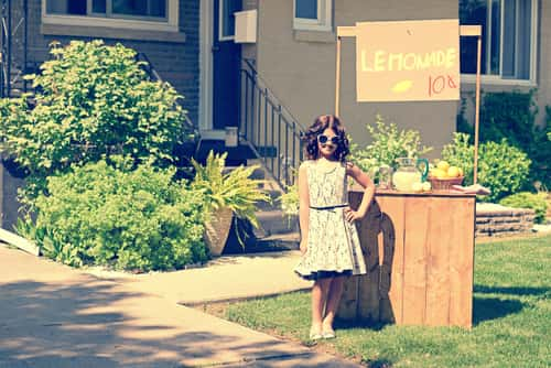 retro girl in front of lemonade stand