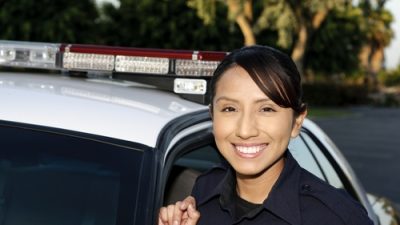Female Police officer standing by patrol car