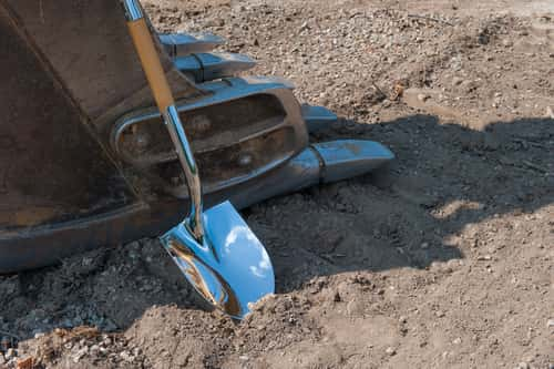 Shovel resting against a construction vehicle