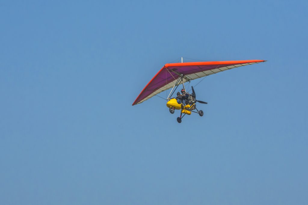 An ultralight aircraft flying in a clear sky