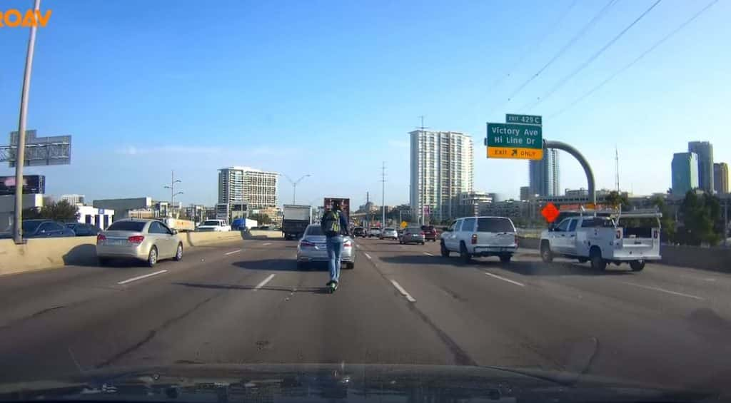 Screenshot of YouTube video showing man on scooter on I-35 in Dallas