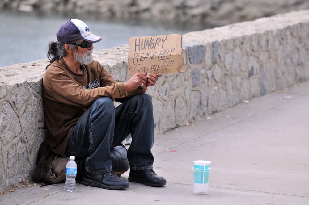 Homeless man holding a sign