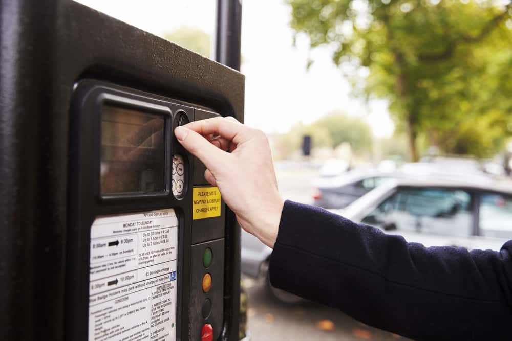 person paying a parking meter