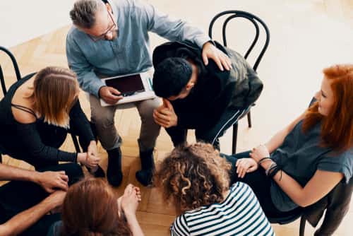 Counselor with students sitting in a circle