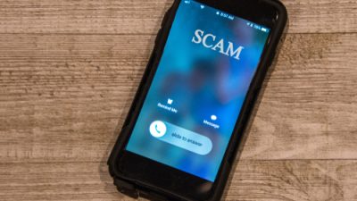 Phone receiving call that says "Scam"