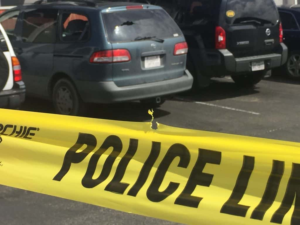 Car damaged by gunfire, police tape