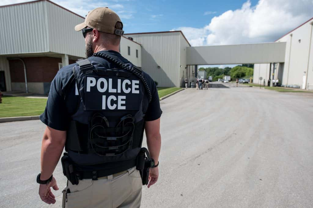 Police ICE agent preparing to arrest alleged illegal immigrants