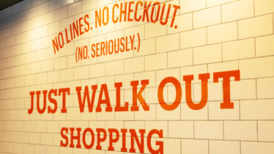 Amazon Go sign that reads "No Lines. No Checkout. (No seriously) Just Walk Out Shopping"