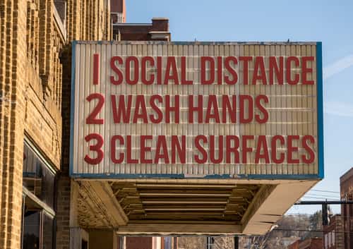 Movie theater sign that reads: "1. Social Distancing, 2. Wash Hands, 3. Clean Surfaces"