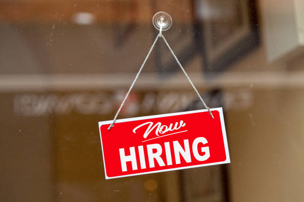 red-sign-hanging-at-the-glass-door-of-a-shop-saying-now-hiring